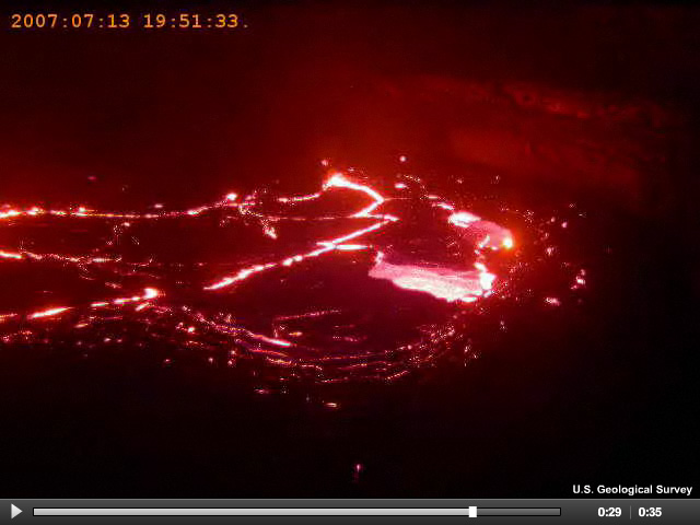 A video of lava rising out of a small vent.  As night falls, the red glow of the lava outlines the lava segments.