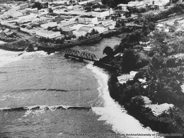 A late tsunami wave in the 1946 tsunami approaching the Hailuku Bridge in Hilo.
